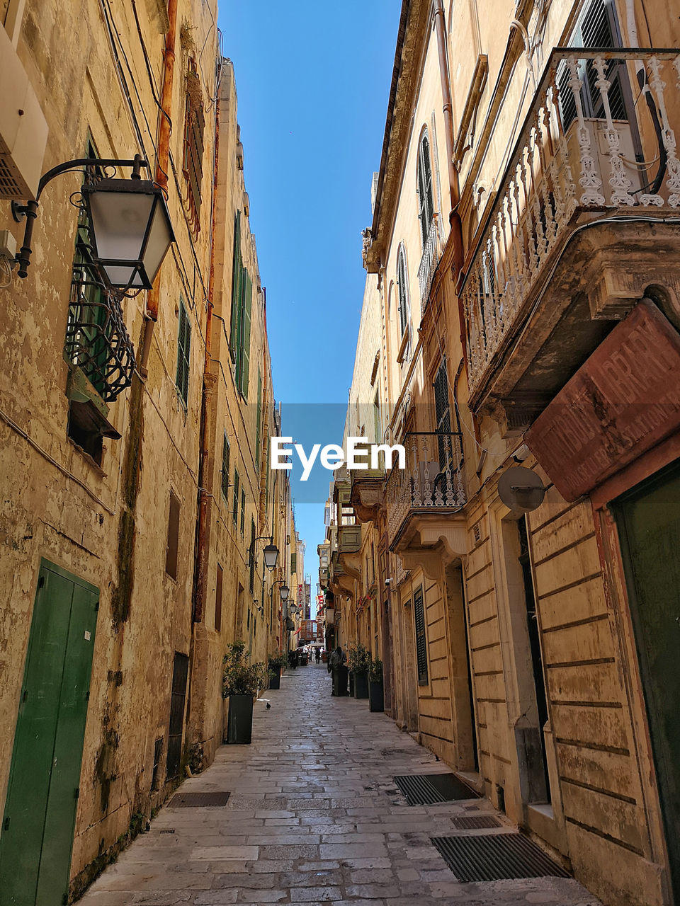 Low angle view of narrow alley amidst buildings in city of valletta, malta