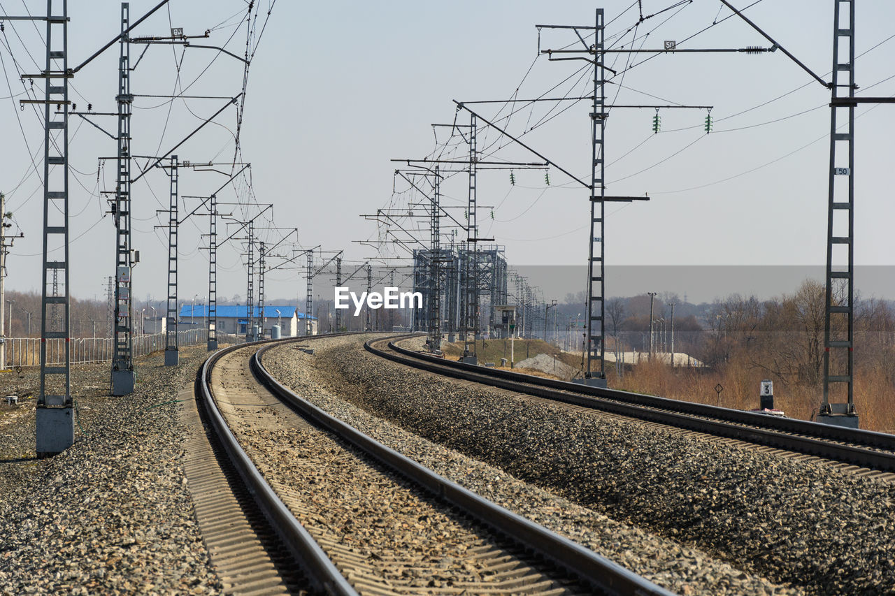 Railroad tracks amidst electricity pylons