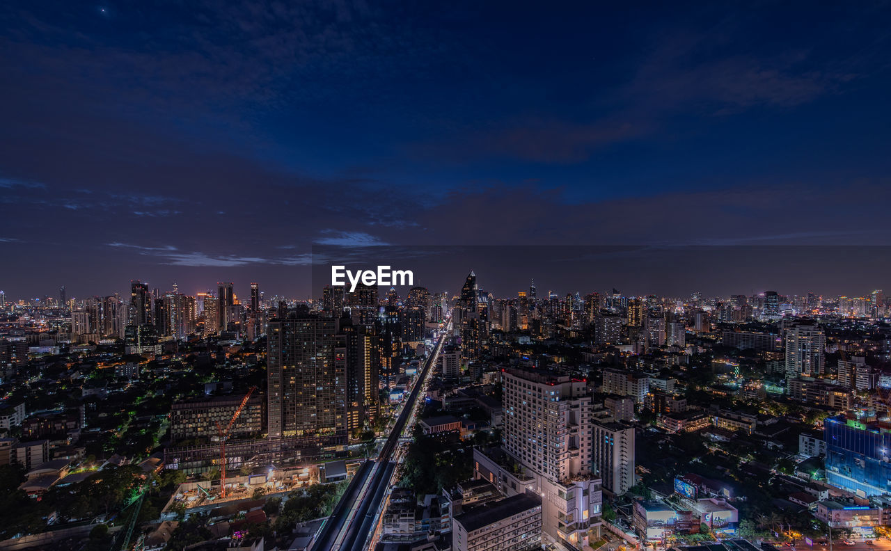 High angle view of illuminated buildings against sky at night