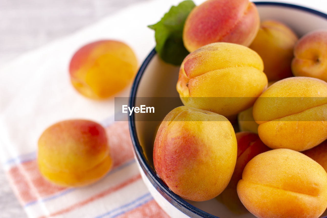 Fresh apricot on a white wooden table. ripe sweet berries in droplets of water