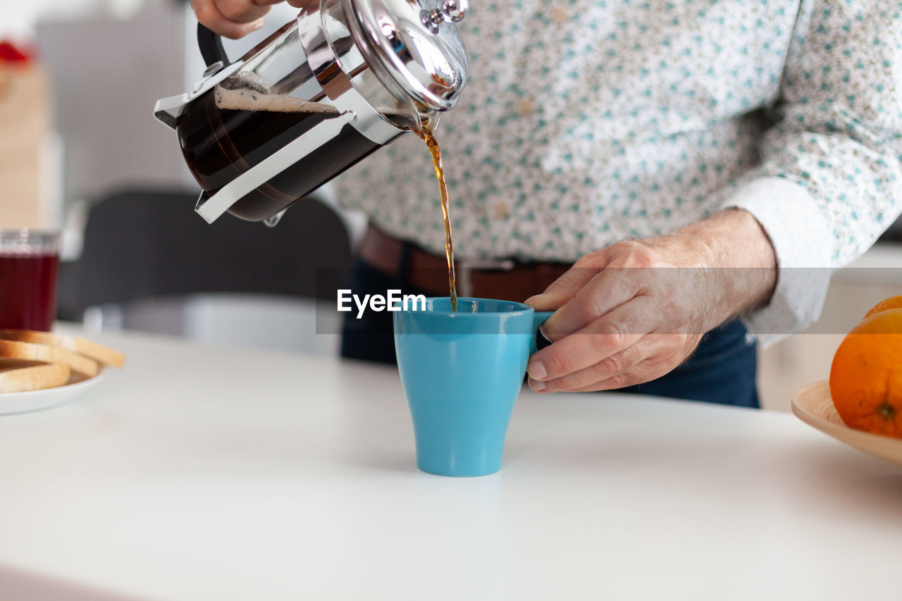 Midsection of coffee cup on table