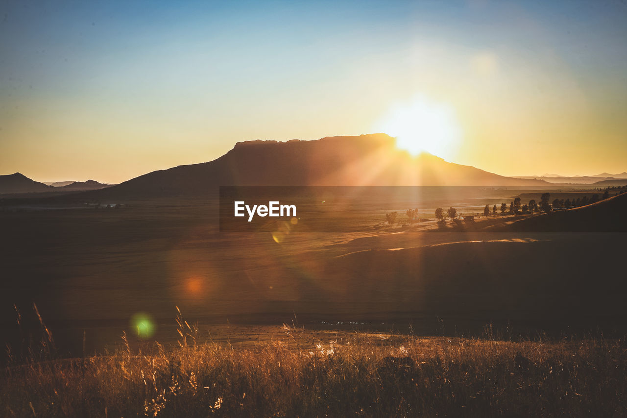 Scenic view of field against sky during sunset