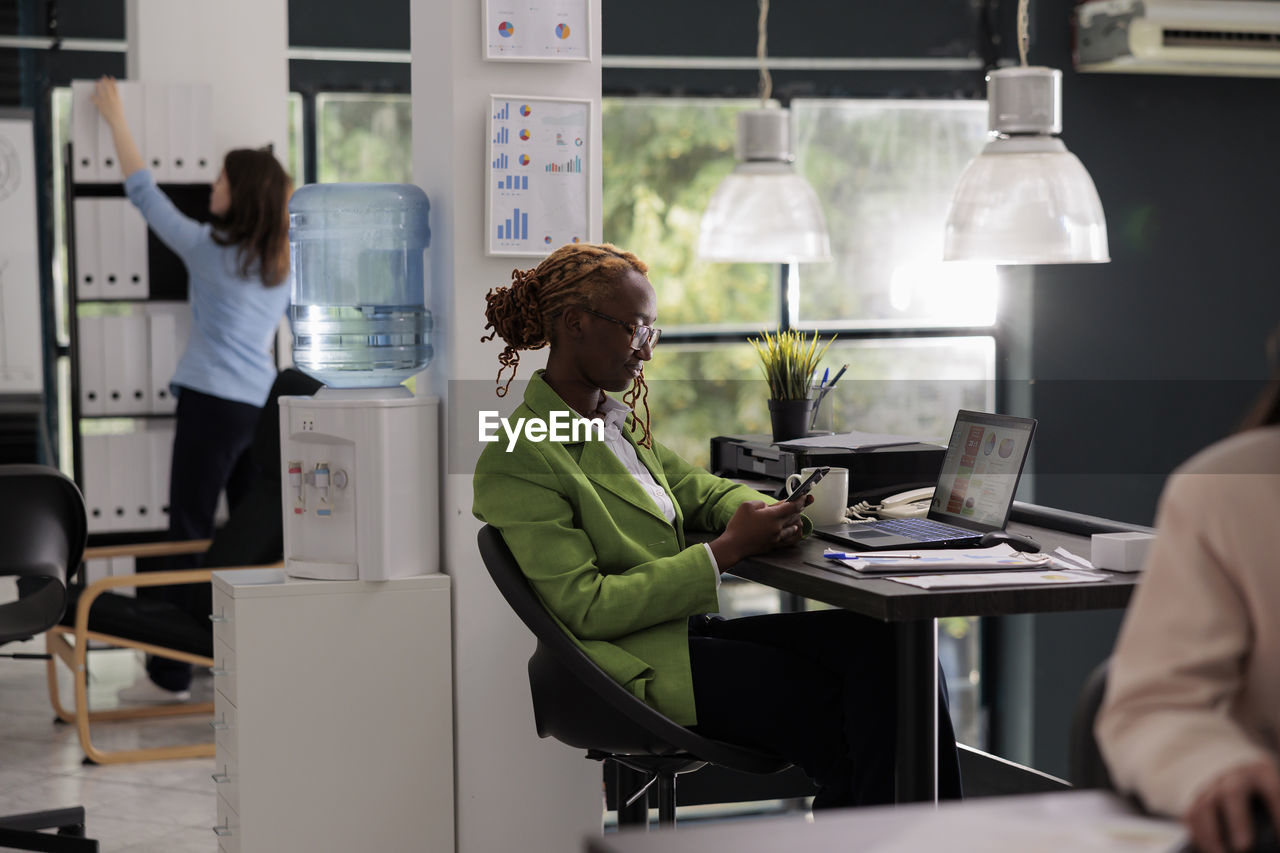 rear view of businesswoman using laptop at office