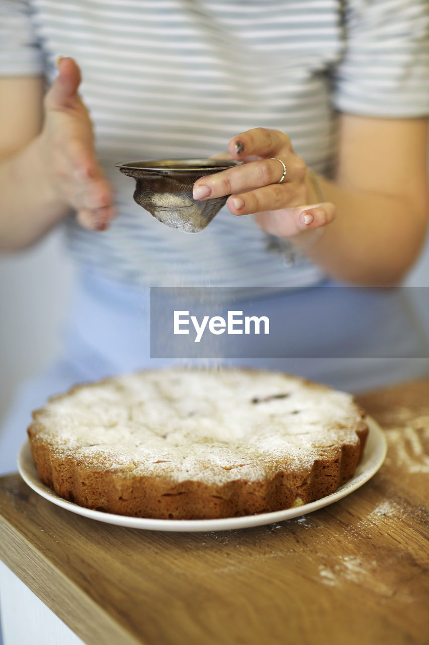 Midsection of woman making cake