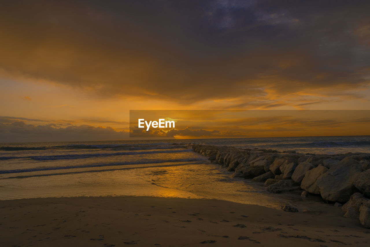 Scenic view of beach against sky during sunset