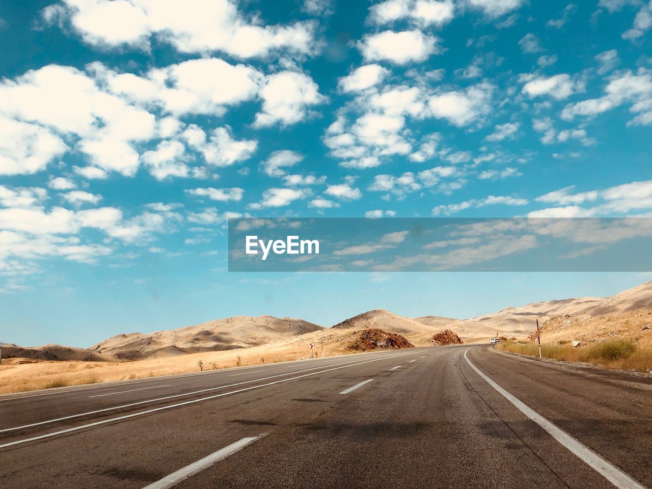 Road passing through dessert against sky