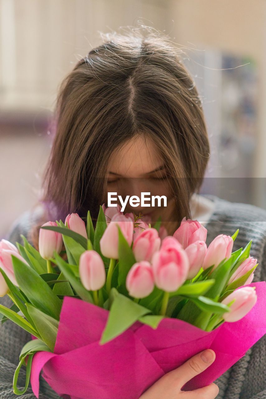 CLOSE-UP OF GIRL HOLDING PINK FLOWER