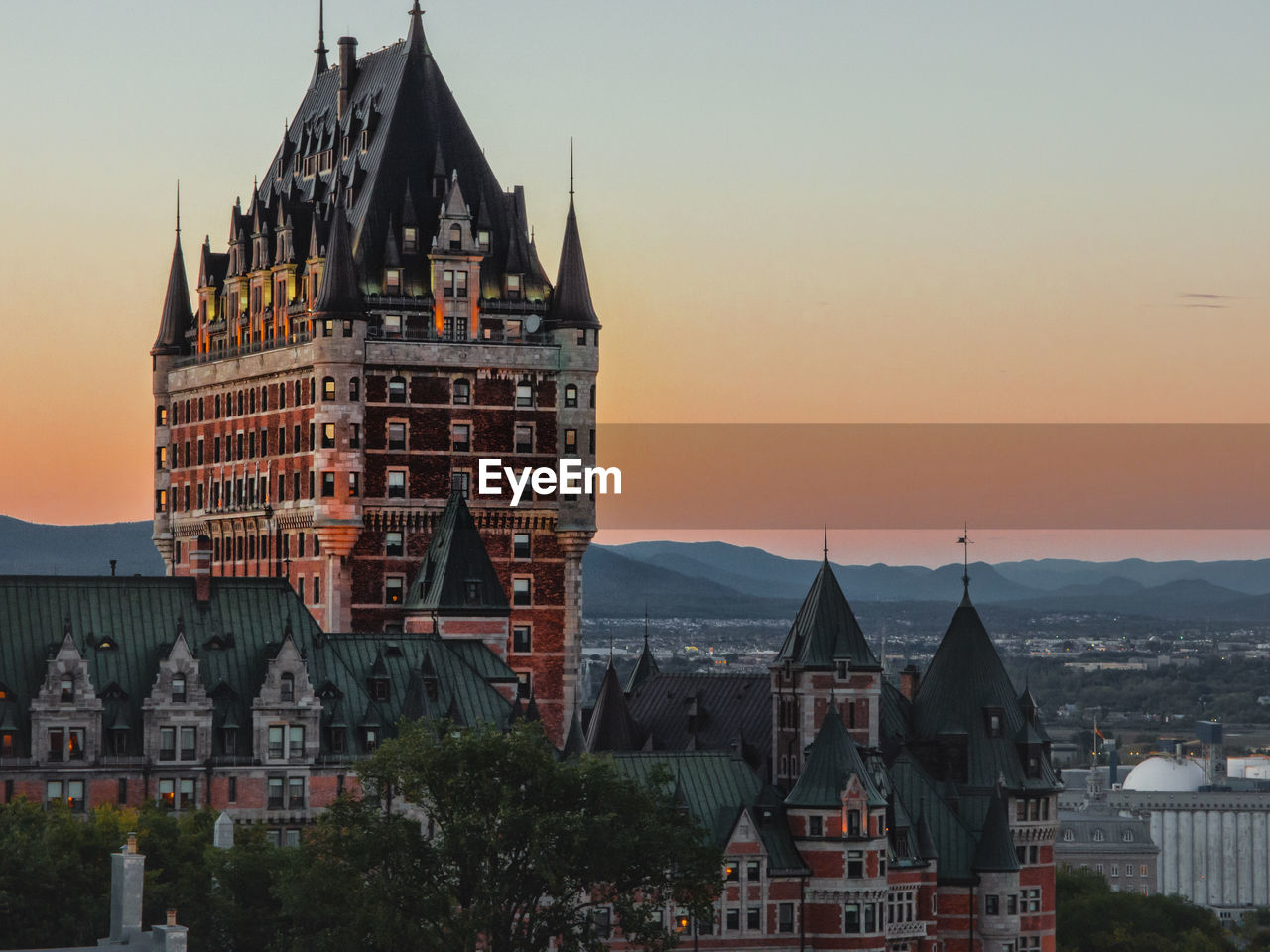 Chateau frontenac in city against sky during sunset