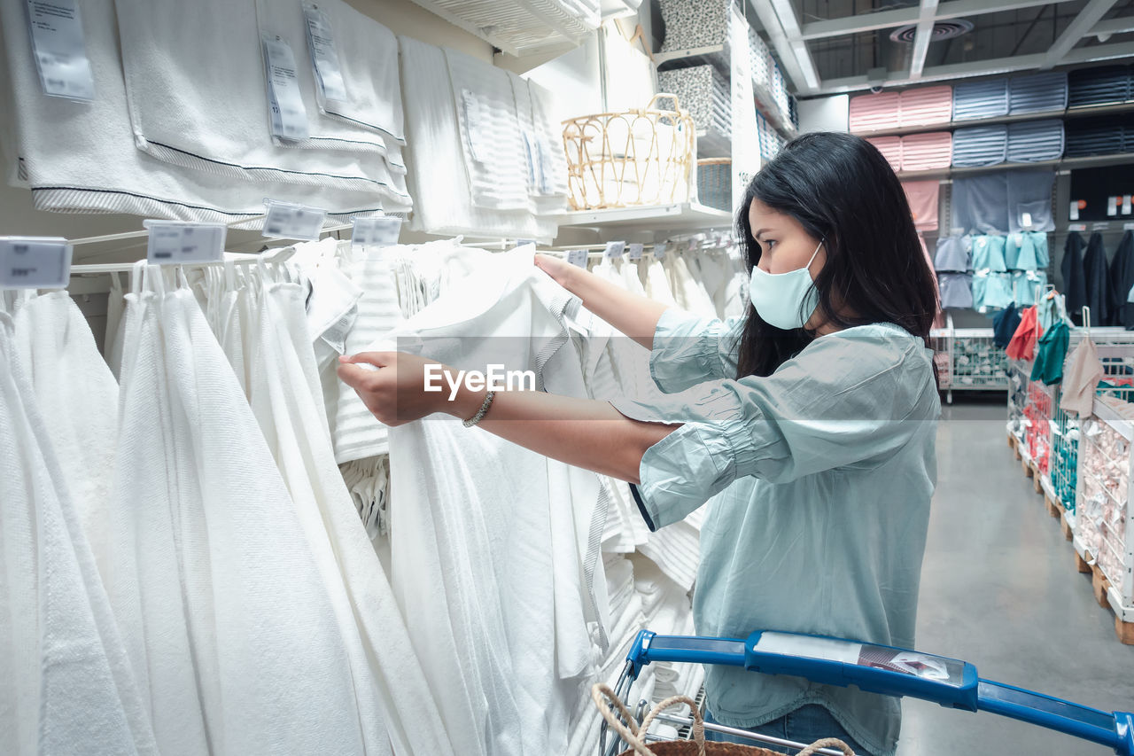 Side view of woman shopping in clothing store