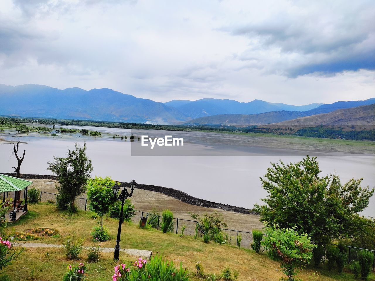 water, mountain, sky, scenics - nature, plant, environment, lake, nature, landscape, beauty in nature, reservoir, cloud, tranquility, highland, land, tranquil scene, tree, travel destinations, mountain range, no people, travel, day, non-urban scene, body of water, outdoors, grass, rural area, tourism, beach, coast, shore, rural scene, architecture, idyllic