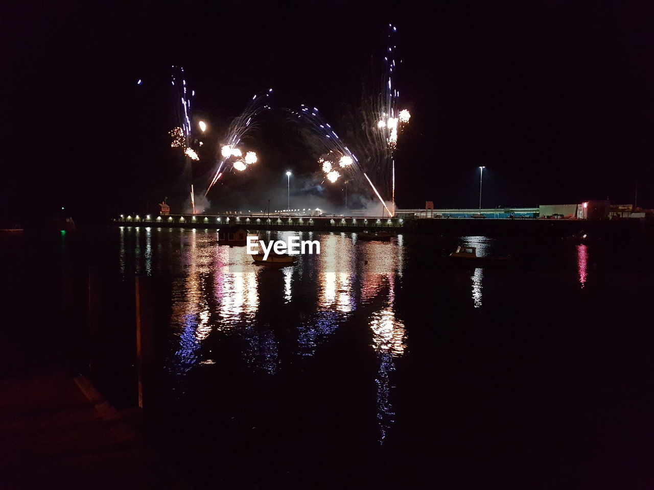 FIREWORK DISPLAY OVER SEA AGAINST SKY