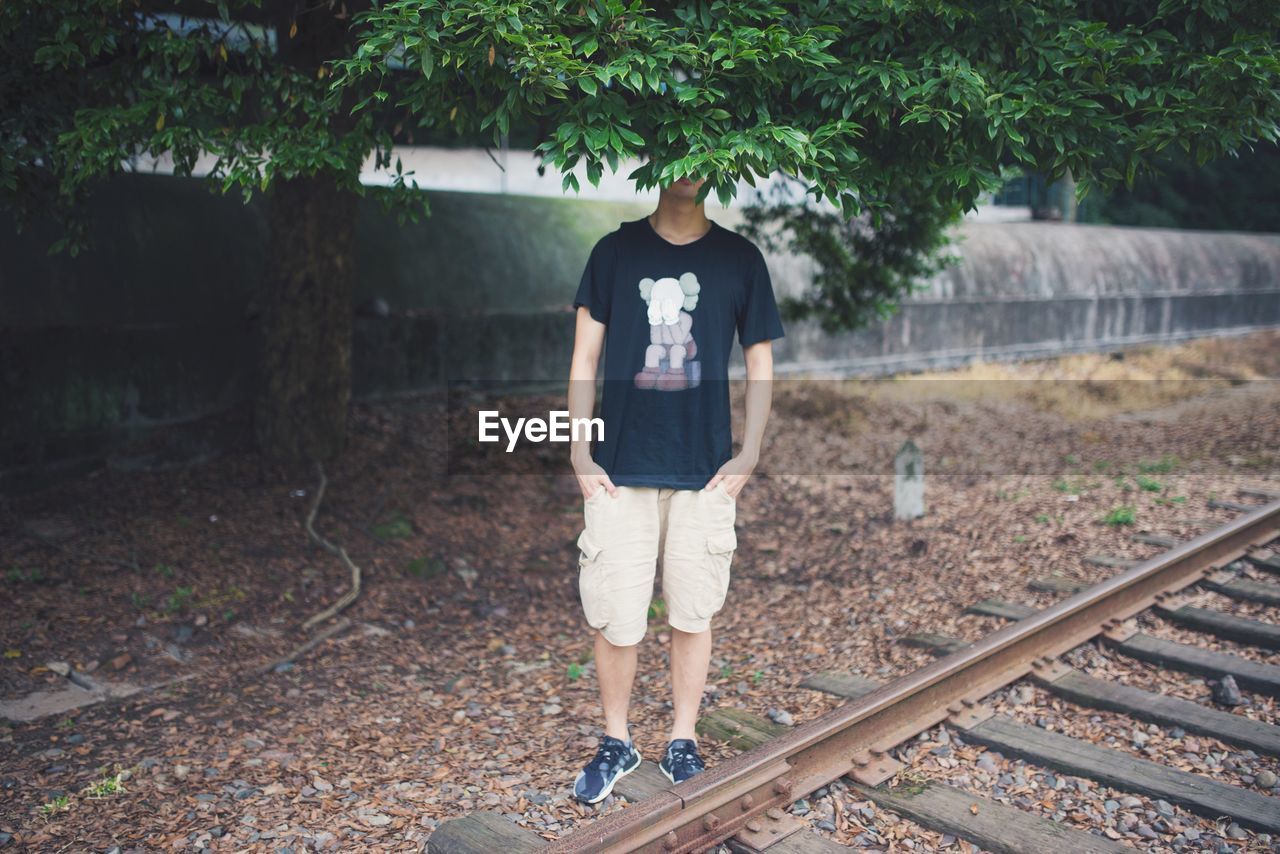 Man standing by railroad tracks