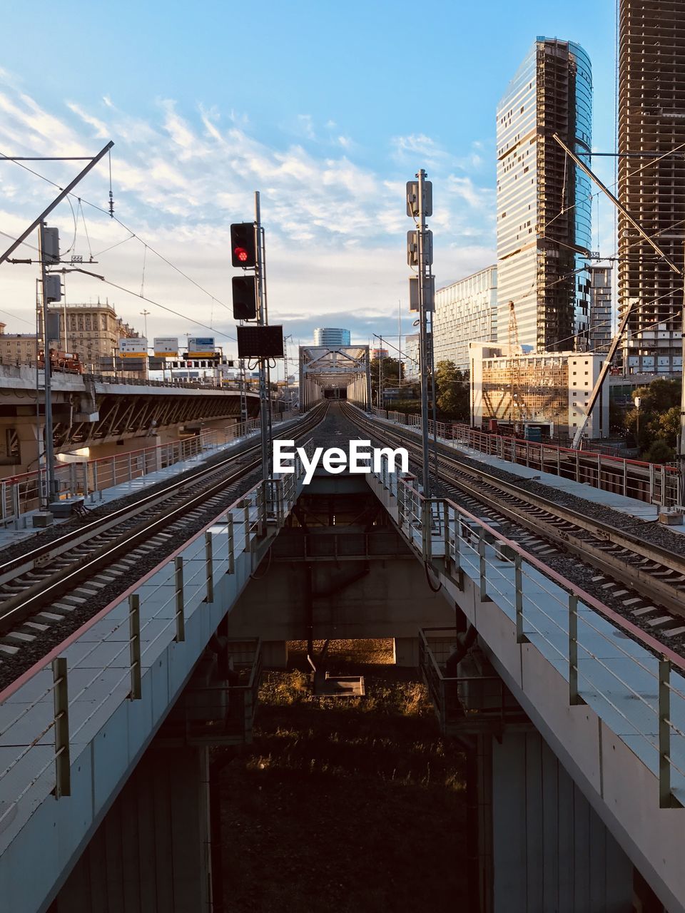 Railroad tracks amidst buildings in city against sky