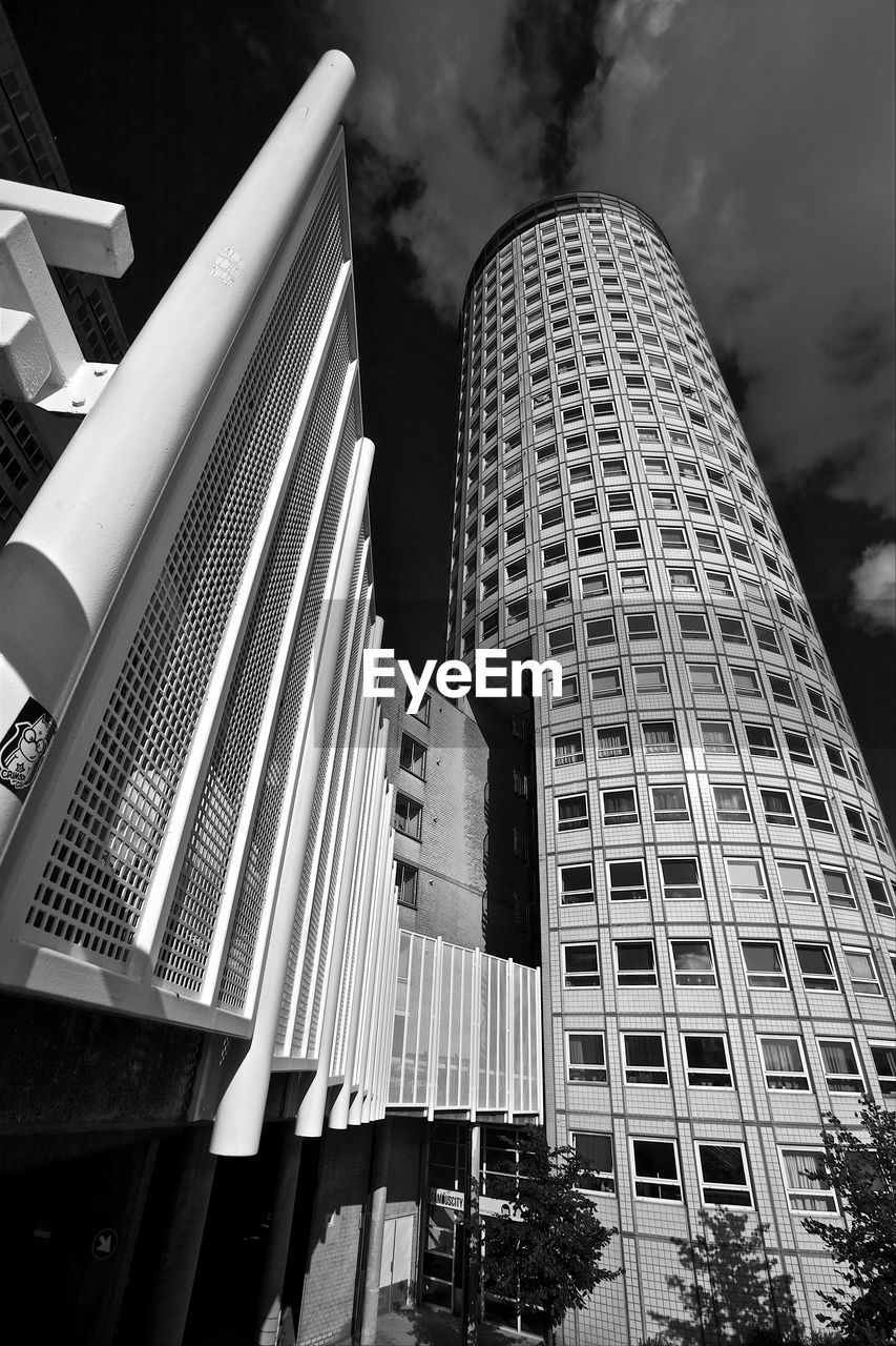 Low angle view of buildings against cloudy sky