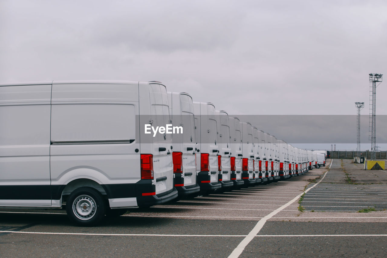 A row of plain white volkswagen crafter vans on the docks at sheerness port, england.