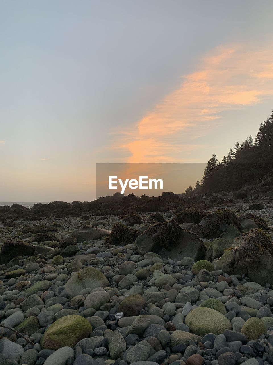 SURFACE LEVEL OF ROCKS AGAINST SKY AT SUNSET