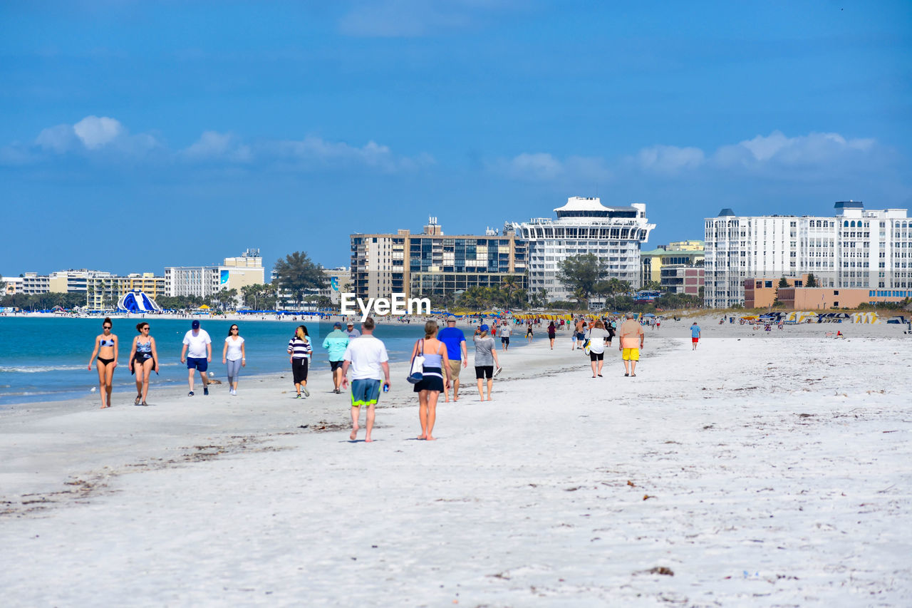 PEOPLE ON BEACH AGAINST BUILDINGS