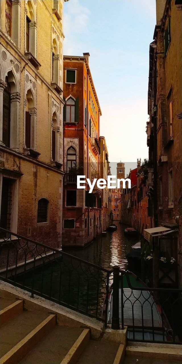 CANAL AMIDST BUILDINGS AGAINST SKY