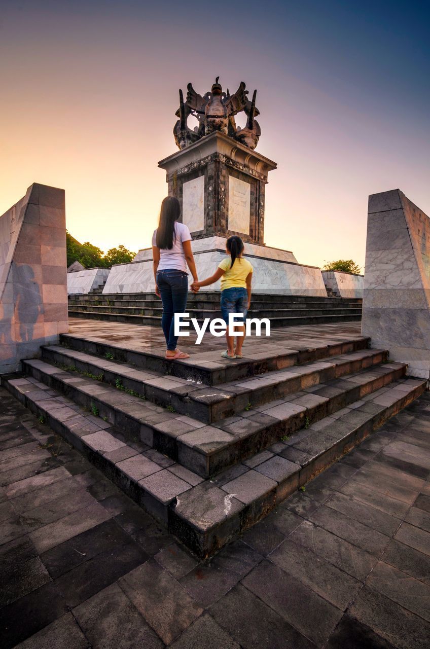 TOURISTS AT TEMPLE AGAINST BUILDING