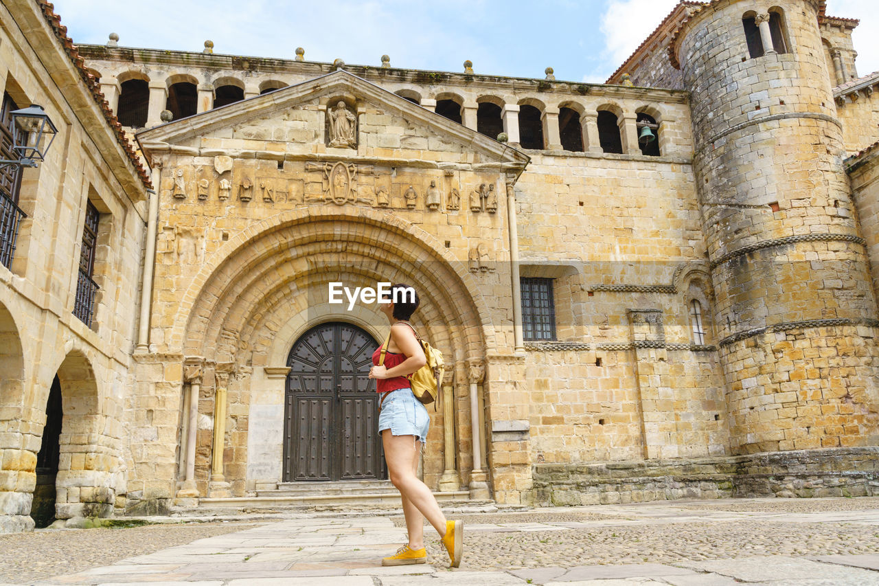 low angle view of woman standing outside historic building