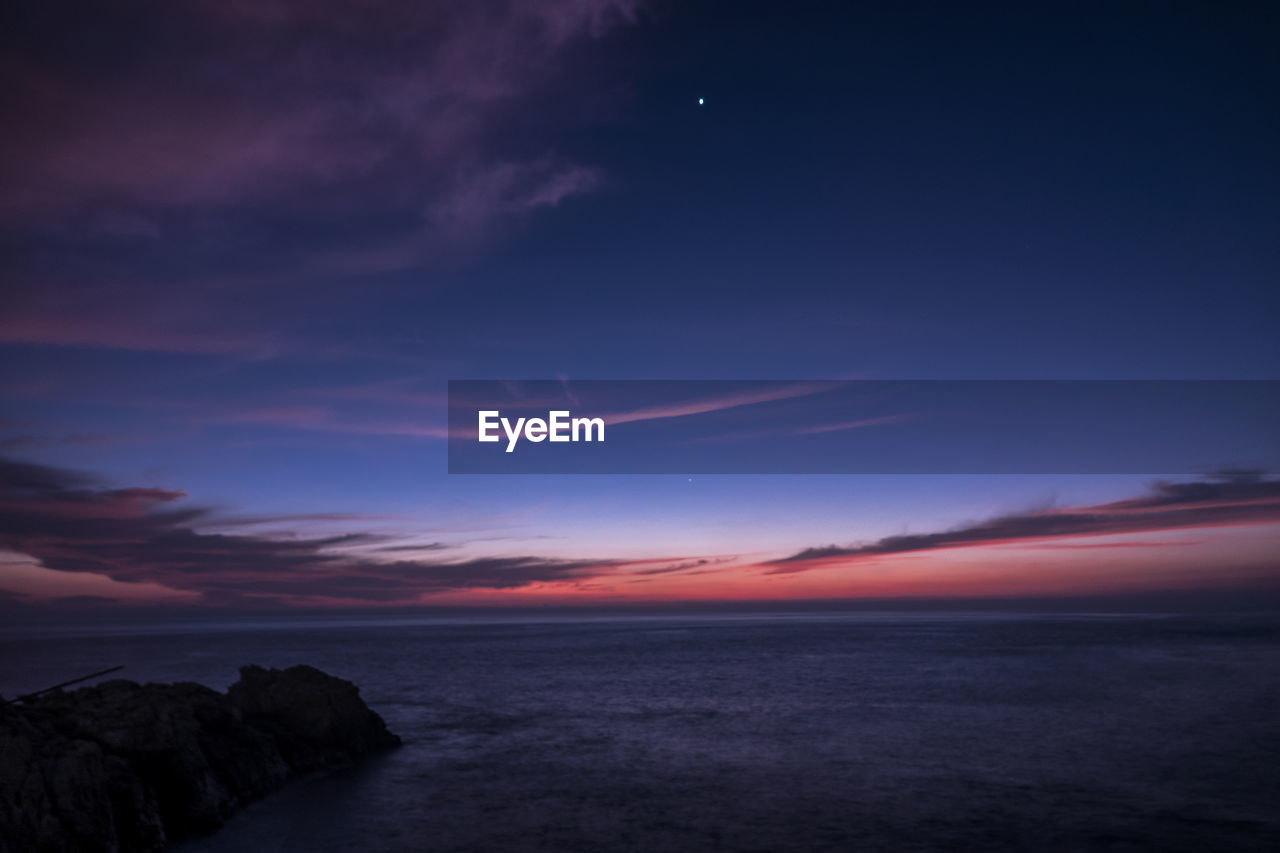 SCENIC VIEW OF SEA AT SUNSET