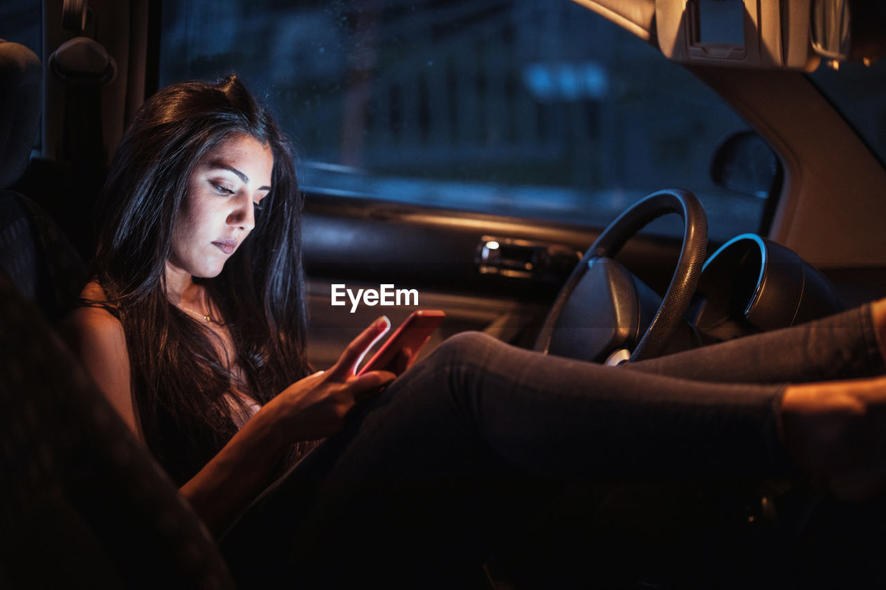 Woman inside a car using her smartphone