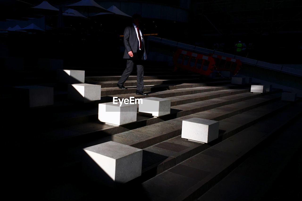 Low angle view of businessman walking on steps at night