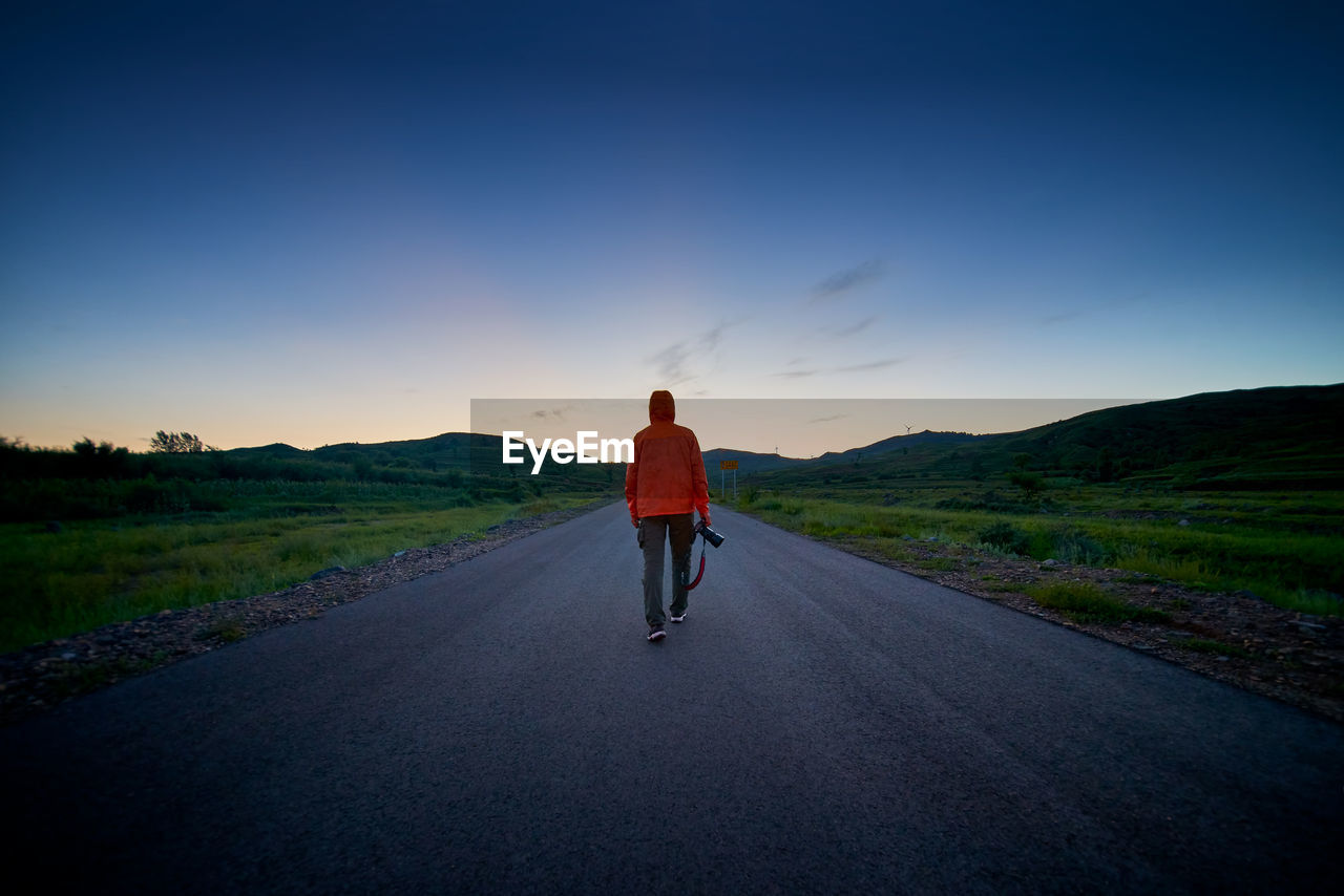 Rear view of man on road against sky