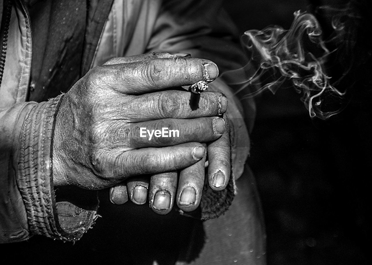 Cropped hands of man holding cigarette