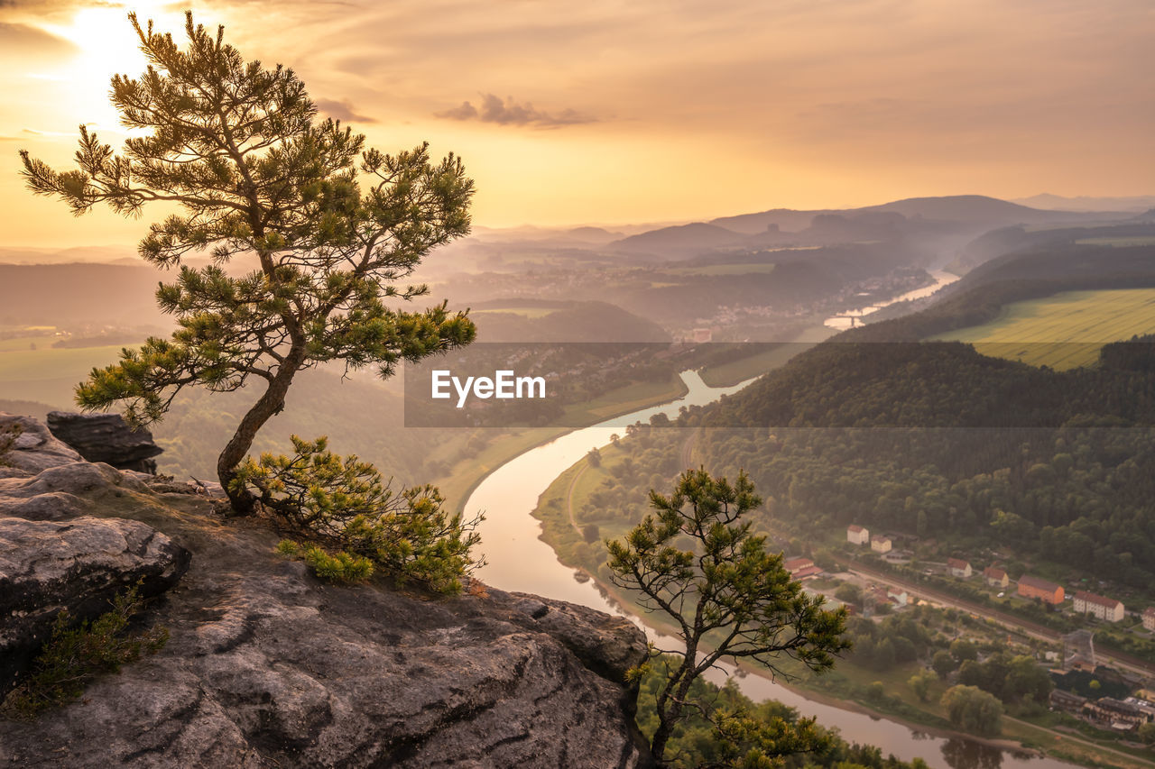 Scenic view of tree mountains against sky during sunset