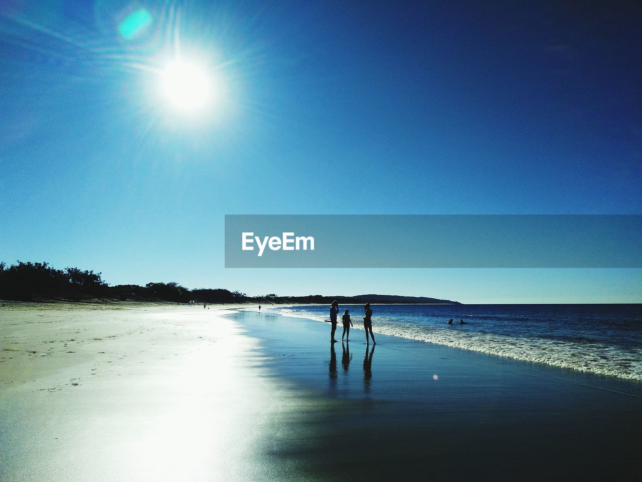 PEOPLE ON BEACH AGAINST CLEAR BLUE SKY