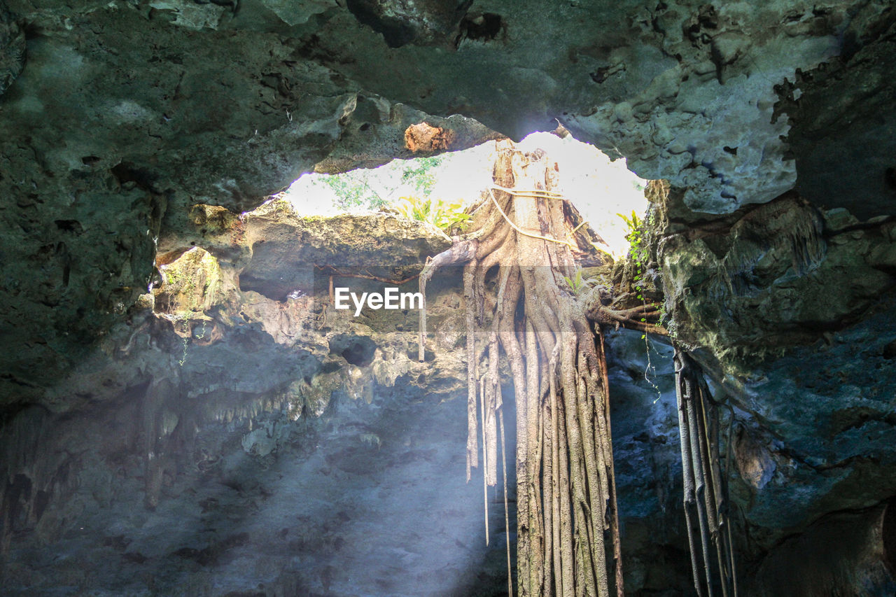 LOW ANGLE VIEW OF SUN SHINING THROUGH CAVE