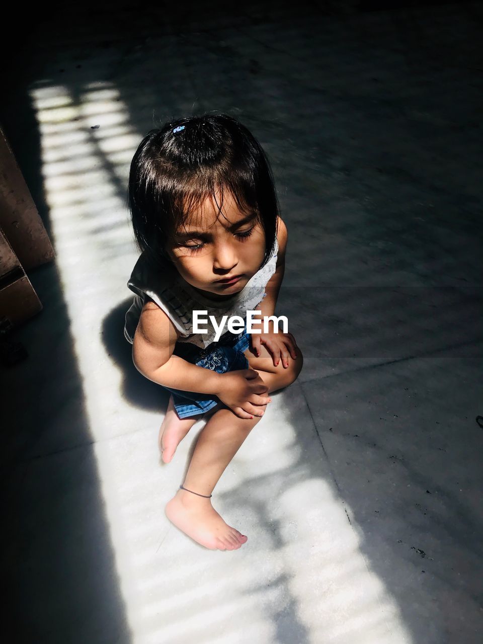 High angle view of cute girl sitting on floor at home