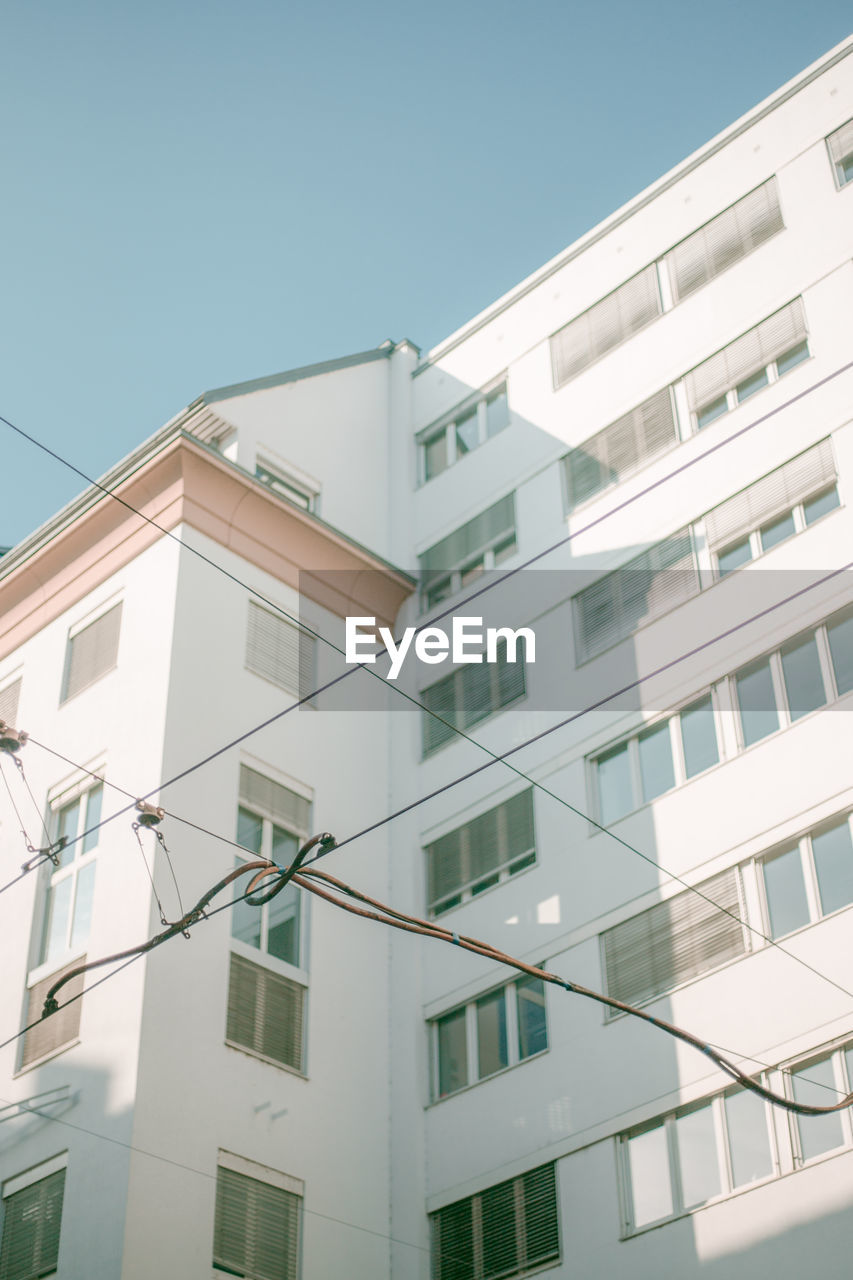 LOW ANGLE VIEW OF RESIDENTIAL BUILDING AGAINST CLEAR SKY