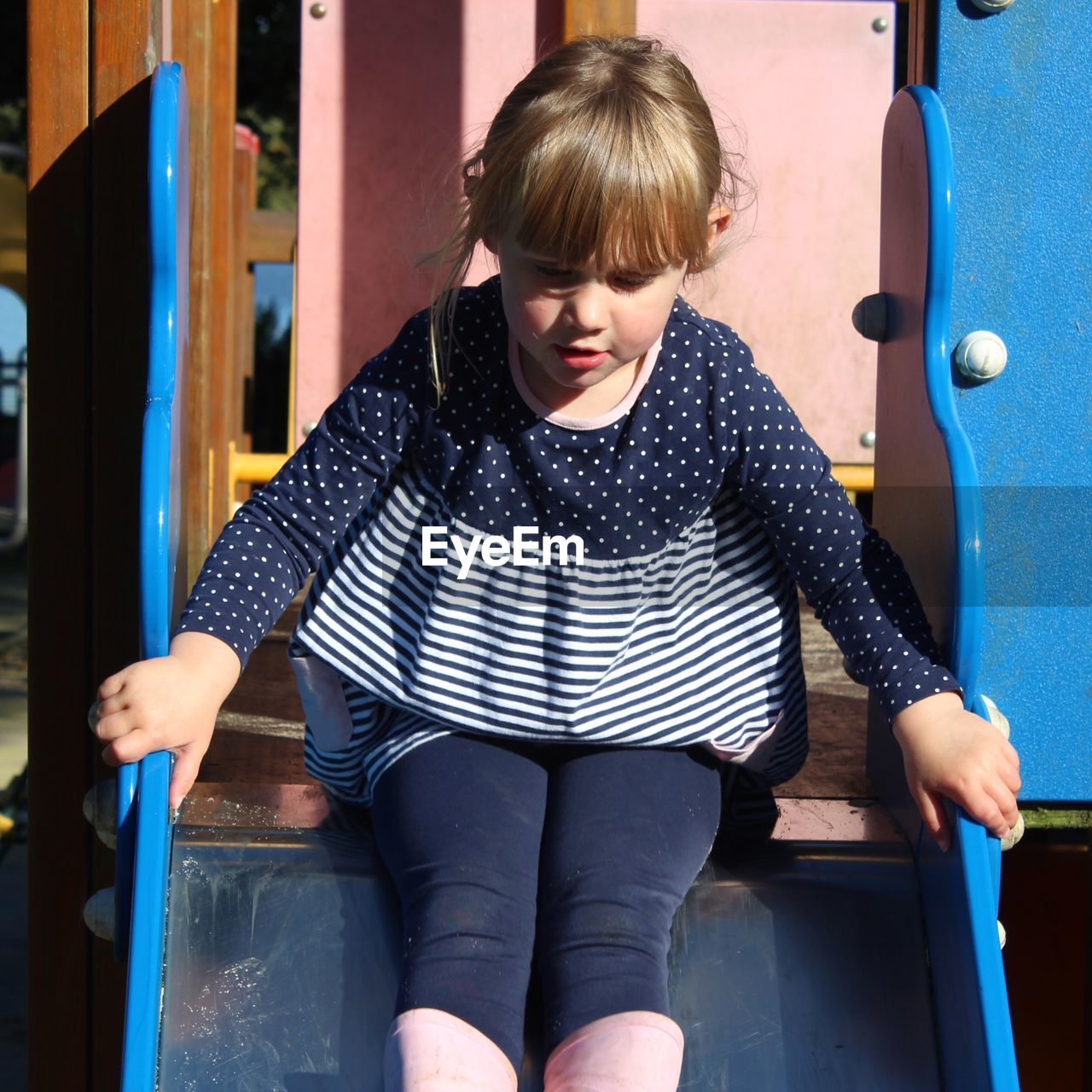 Cute girl sitting on slide