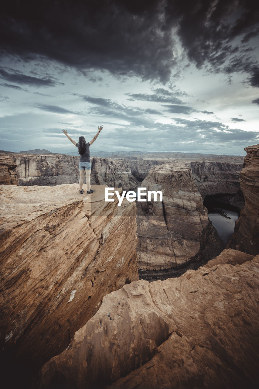 Woman in horseshoe bend point at sunset