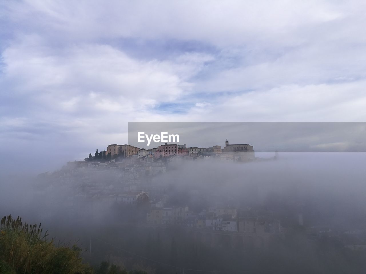 BUILDINGS AGAINST CLOUDY SKY