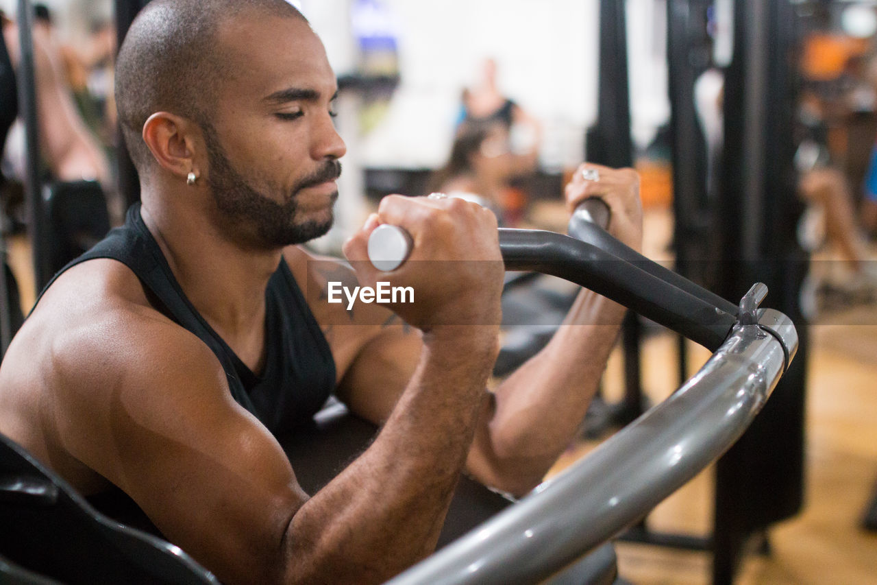 Portrait of young man exercising at gym
