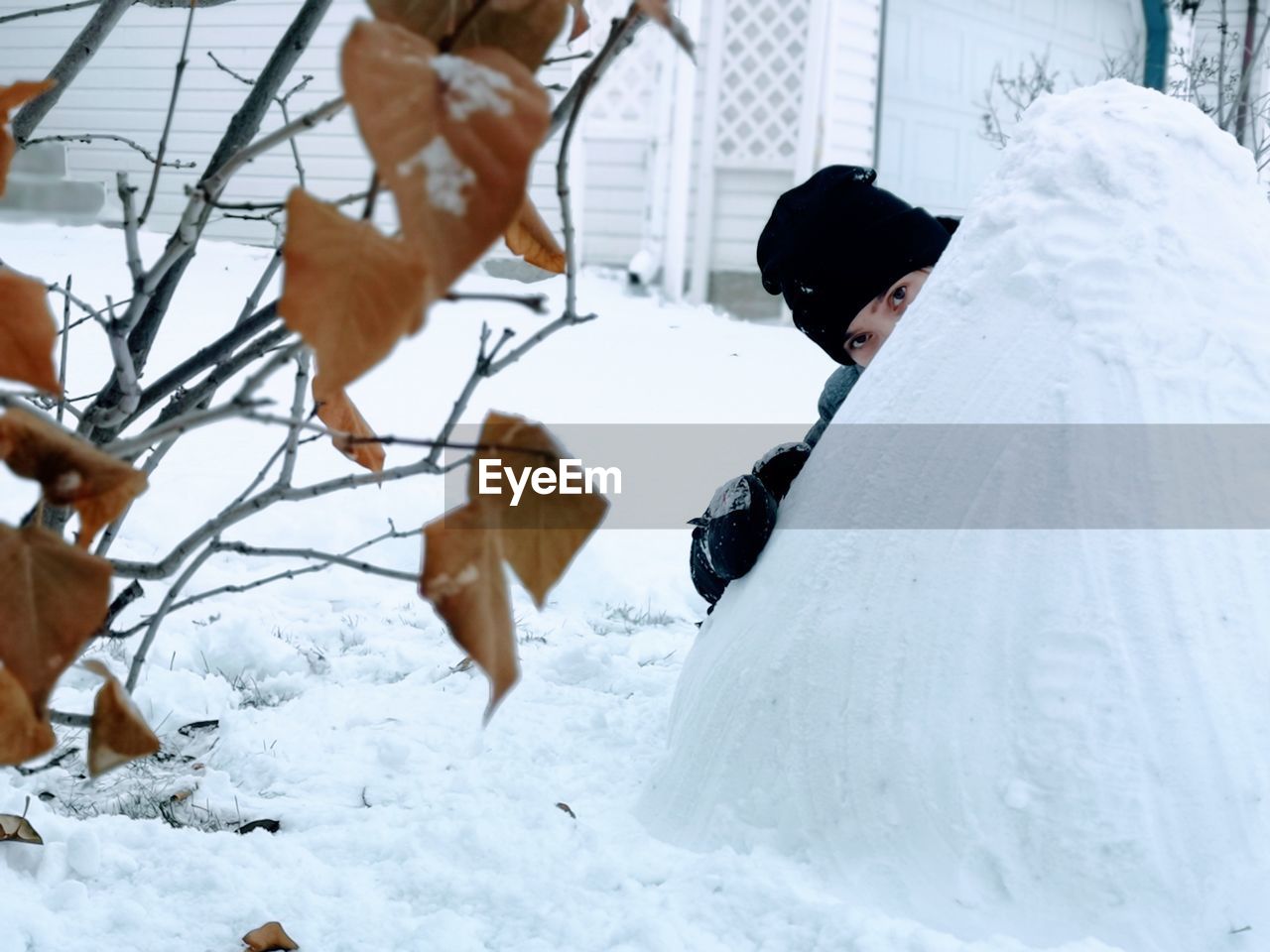 Girl's eyes behind a mound of snow