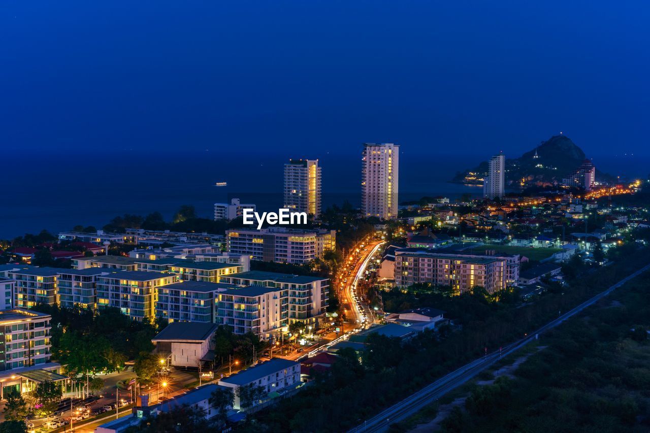 High angle view of illuminated buildings against sky at night