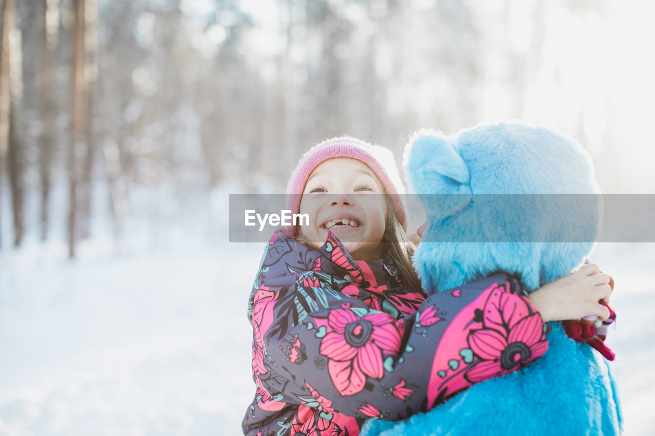 Close-up of smiling girl with father on snow