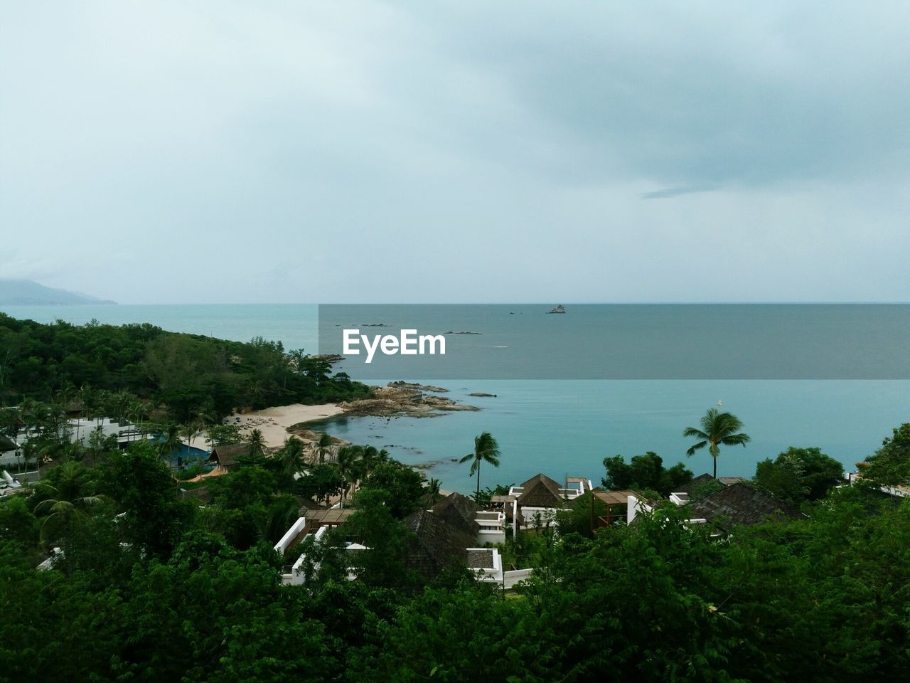 HIGH ANGLE VIEW OF SEA BY BUILDINGS AGAINST SKY