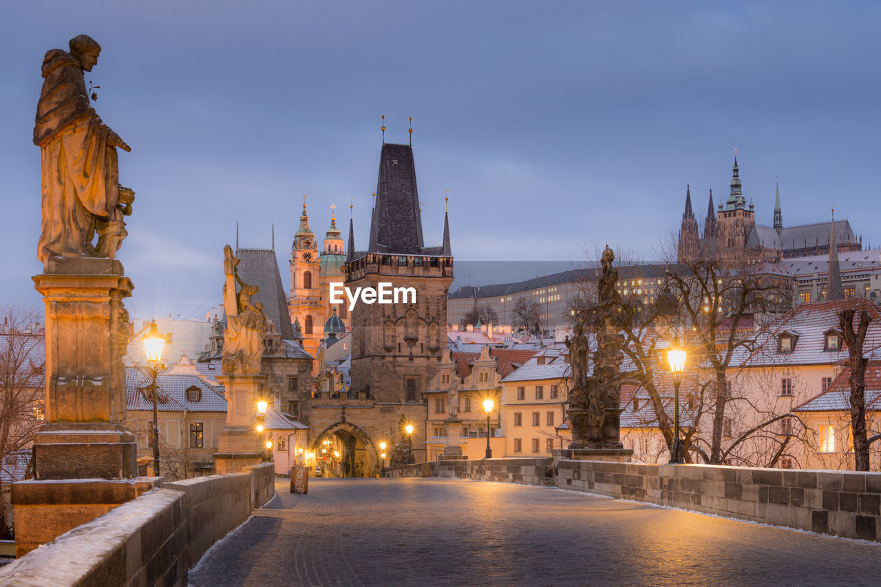 Illuminated buildings in city at dusk