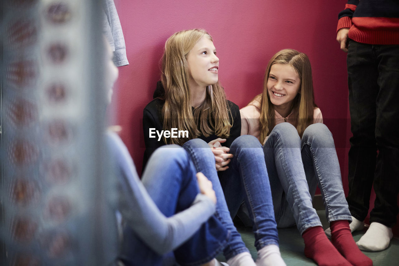 Smiling girls with friends in school building