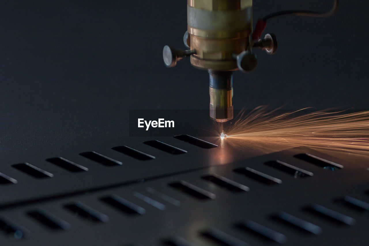 Close-up of illuminated machine in factory