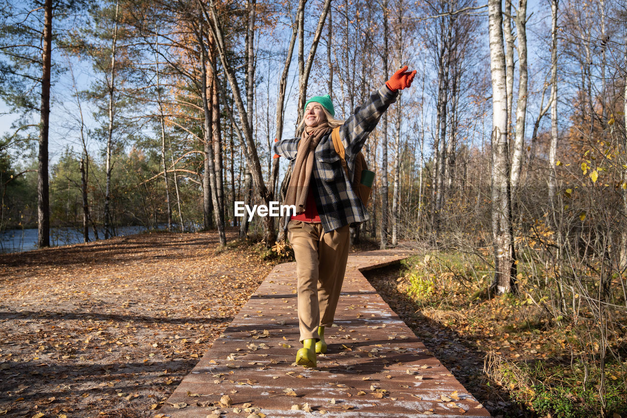 rear view of man walking on field in forest