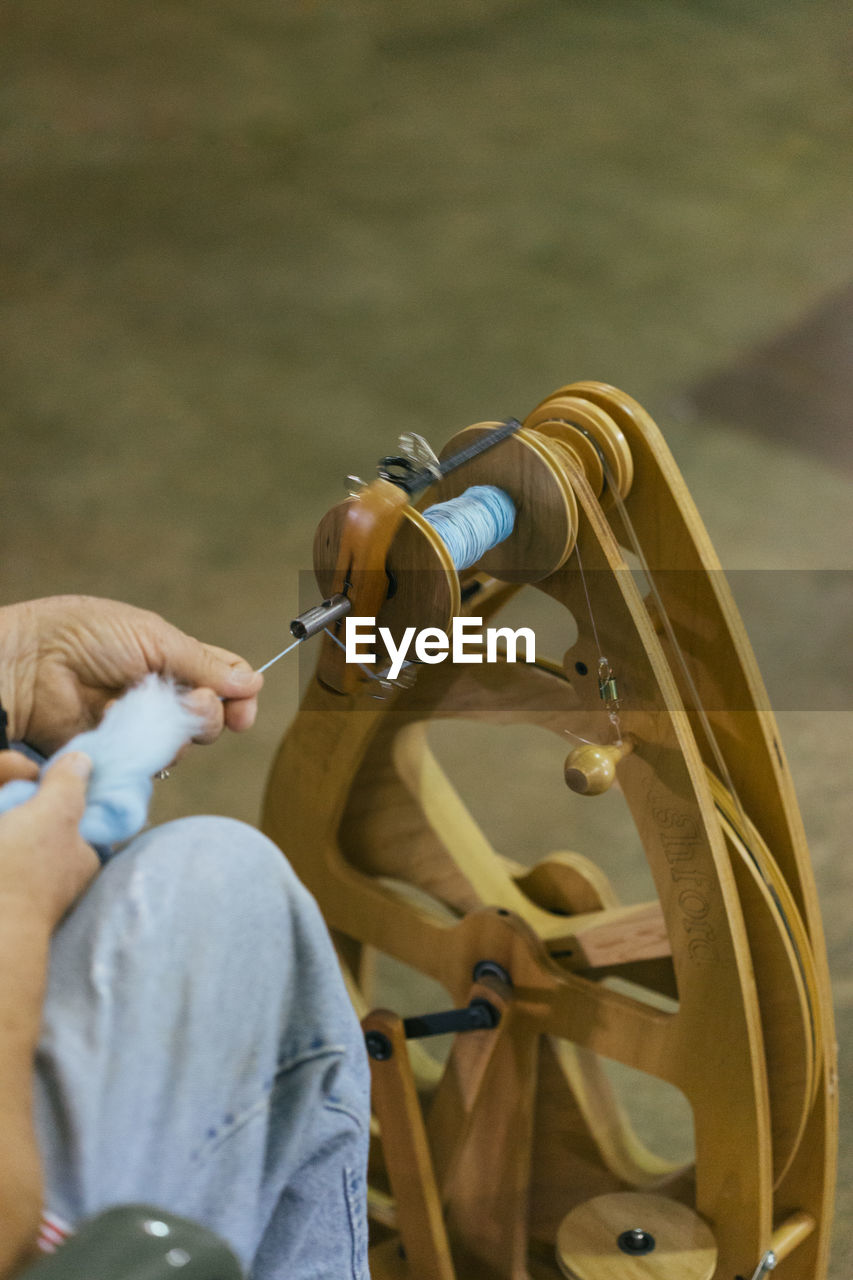 Cropped image of man working with loom in workshop