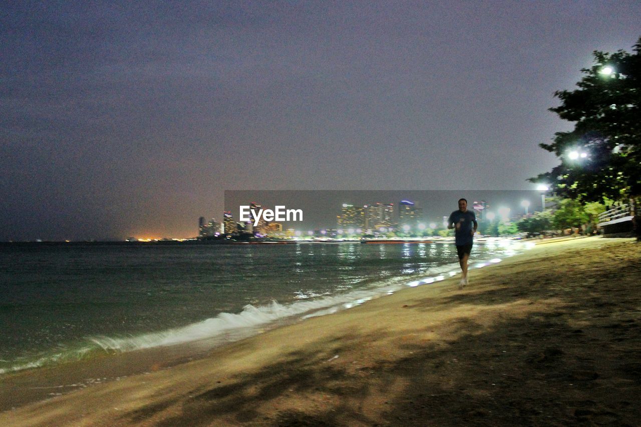 WOMAN WALKING IN CITY AT NIGHT