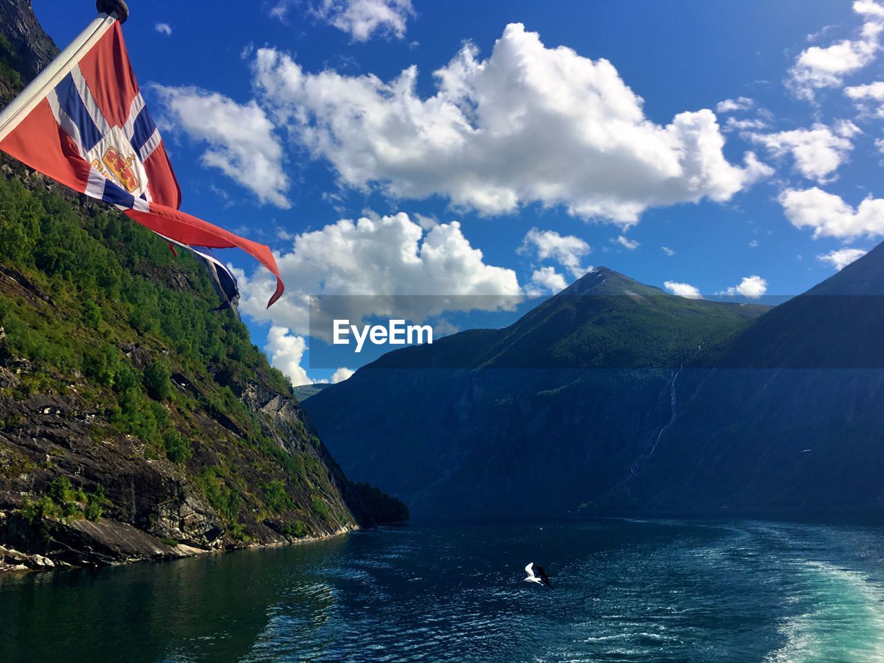 Norwegian flag on mountain at geirangerfjord