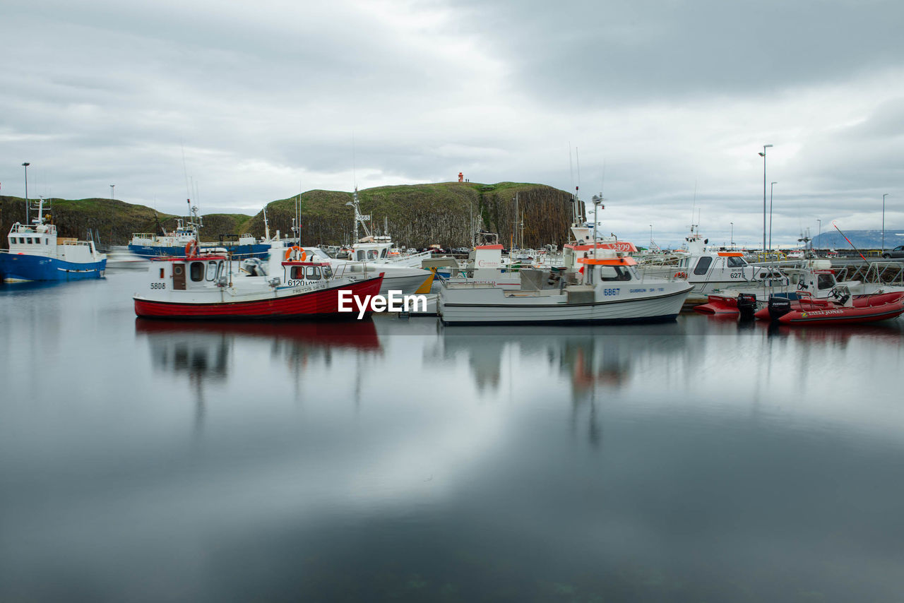 BOATS IN SEA WITH BUILDINGS IN BACKGROUND